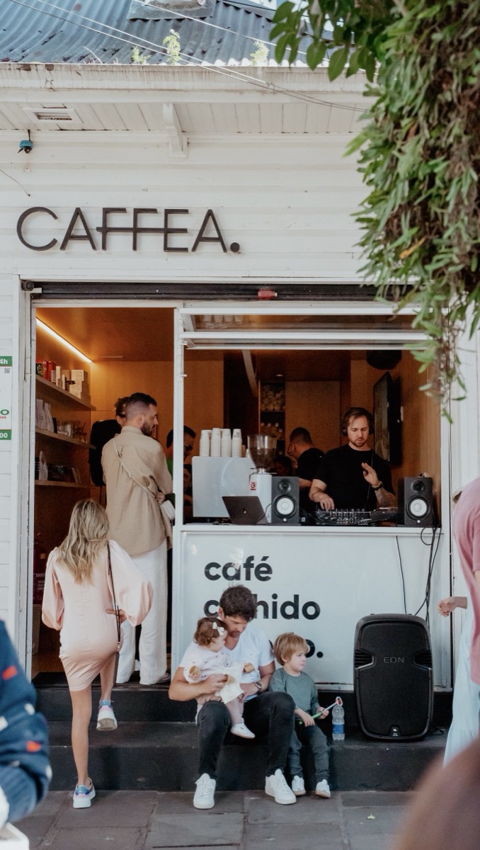 Fachada da CAFFEA com DJ tocando na janela